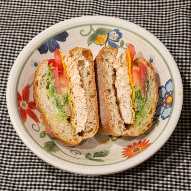 Grilled Chicken with Cheddar, Plum Tomato, Green Goddess Dressing on a Baguette.